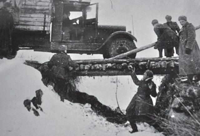 Ingenieros soviéticos asistiendo a un camión que intenta atravesar un puente de madera